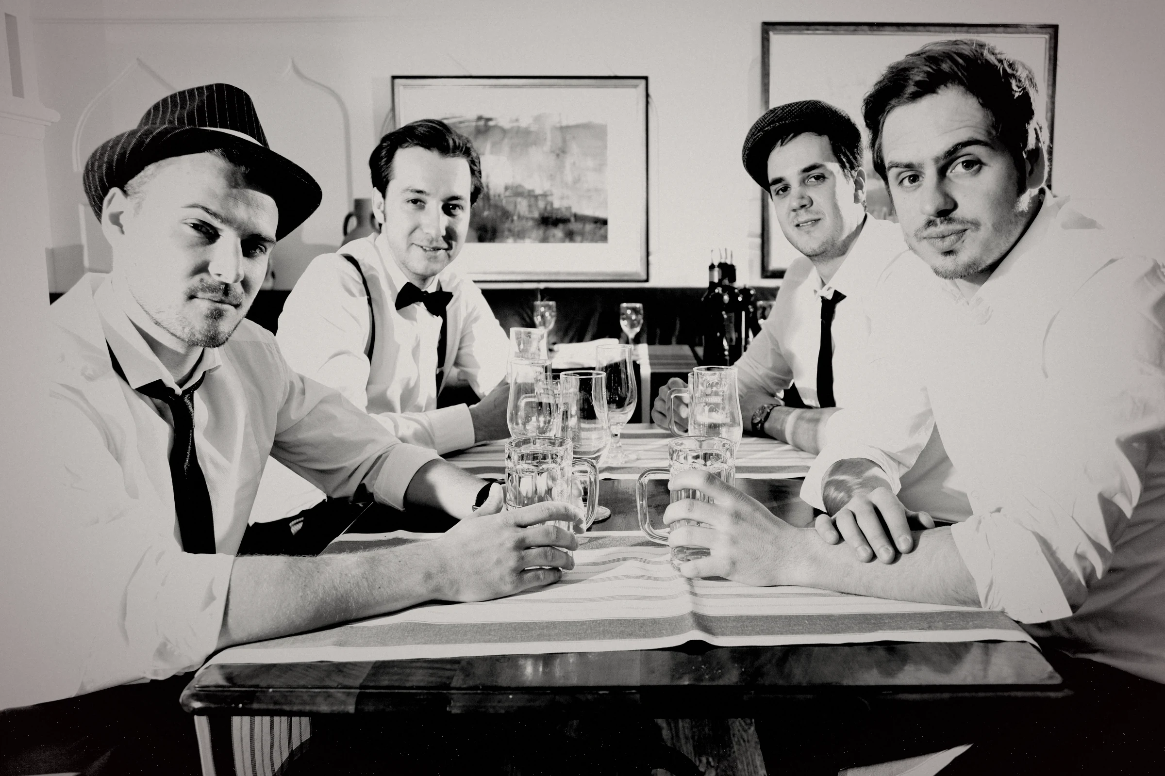 CONFUZED, archival band photograph from 2014: four band members seated together at a table